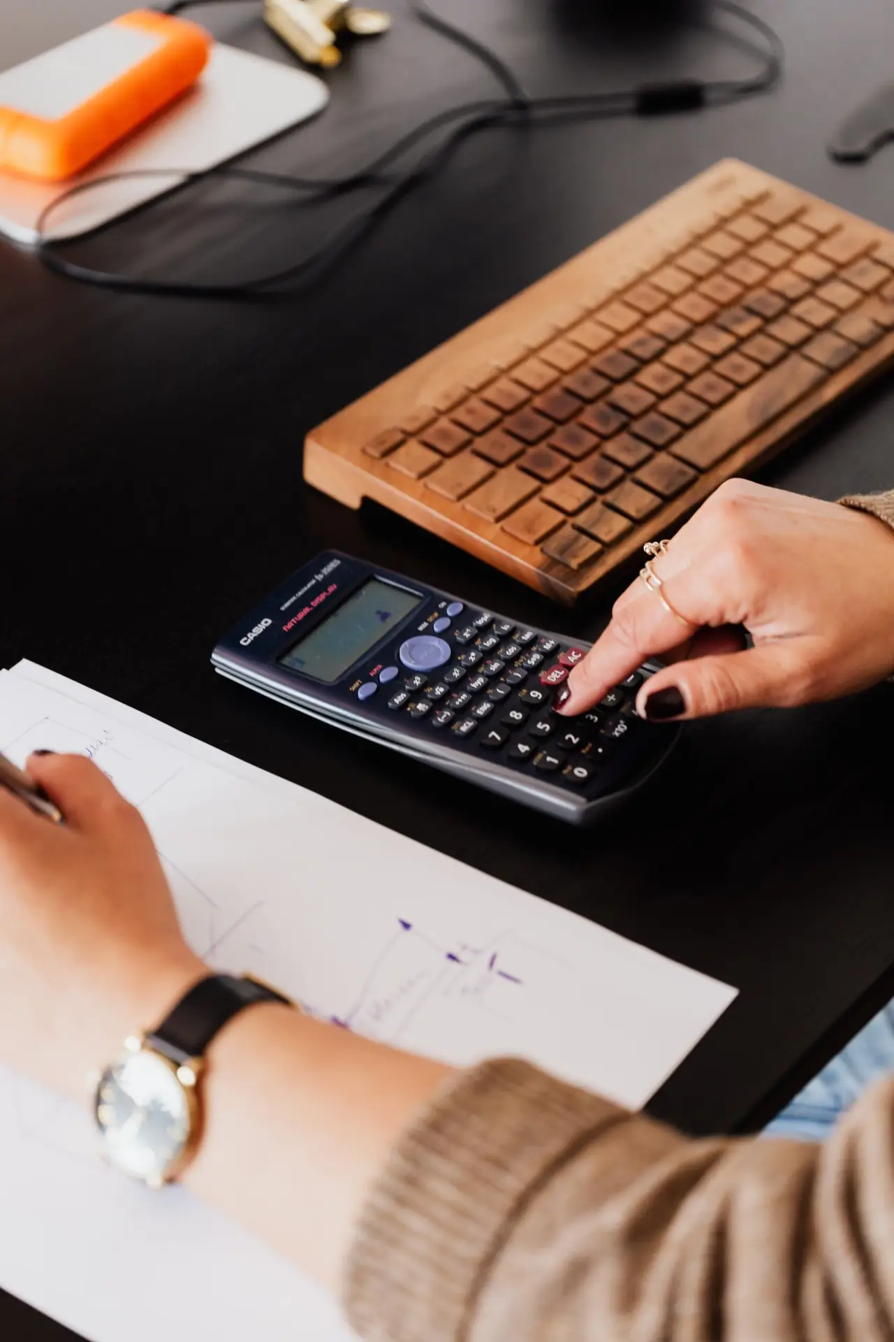 a person using a calculator and taking notes