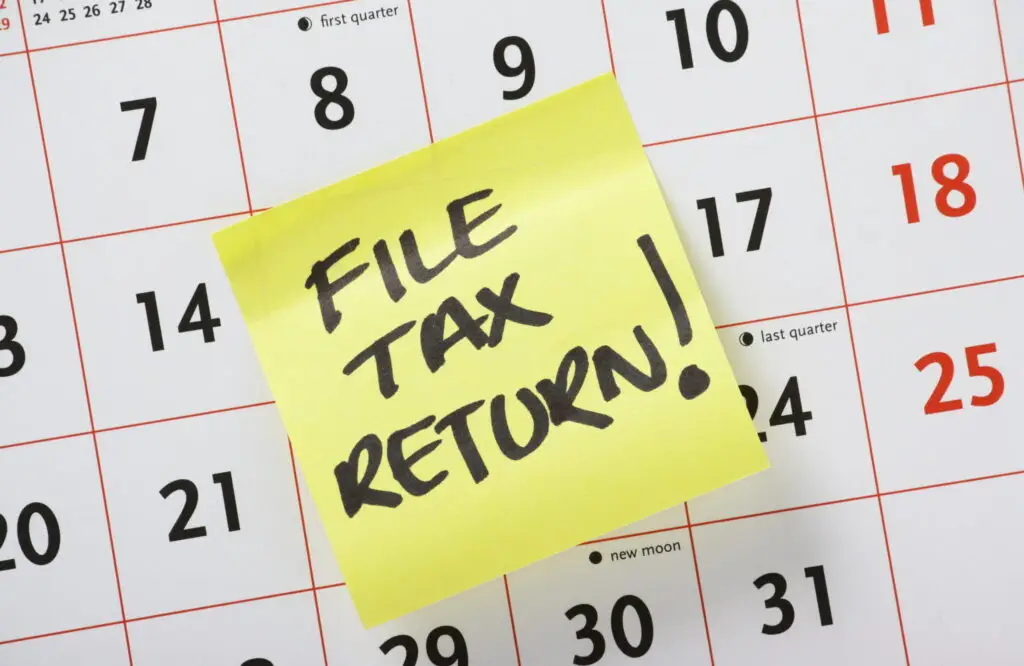 sticky note reminding to file taxes on calendar