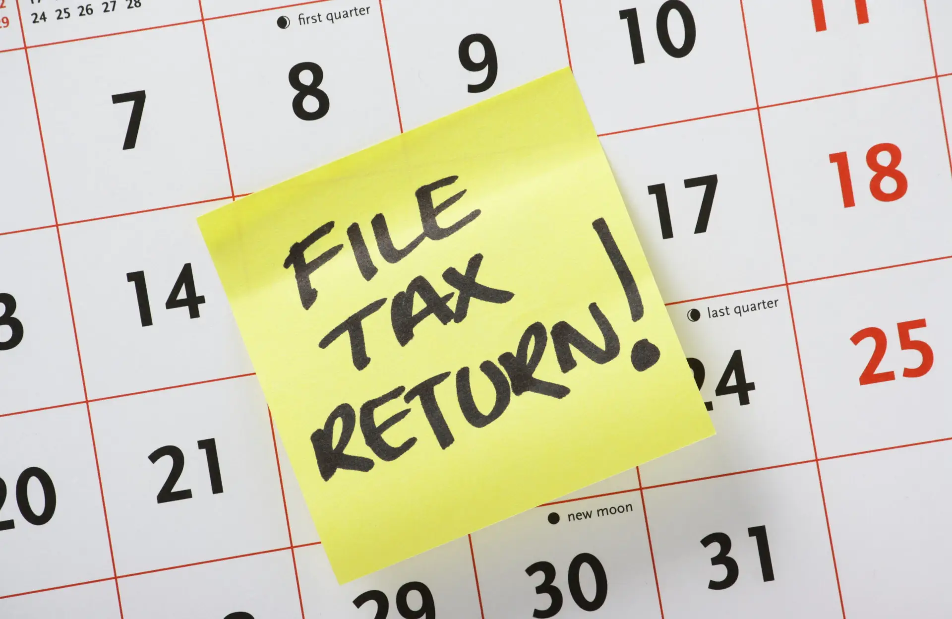 sticky note reminding to file taxes on calendar